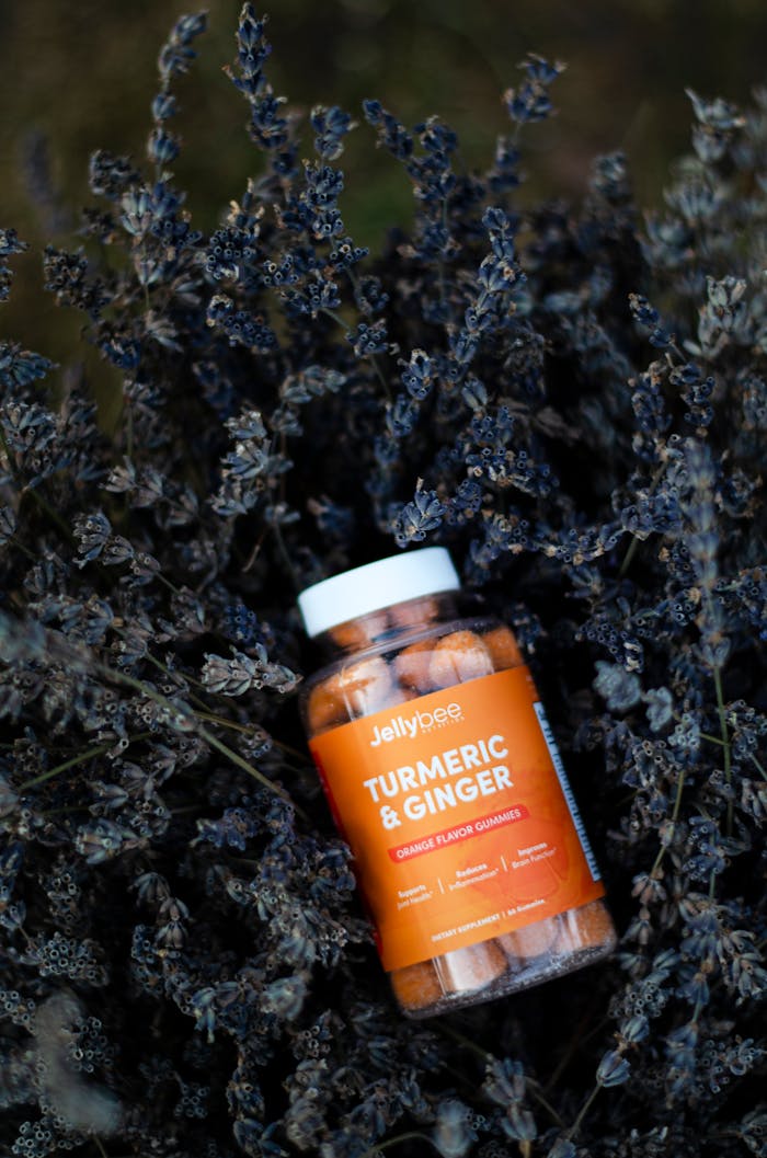 Close-up of turmeric and ginger gummy bottle surrounded by dry lavender, emphasizing natural health.